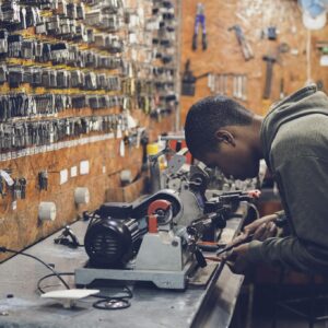 Man in Grey Hoodie Jacket Holding Black Metal Near White Socket Power Supply